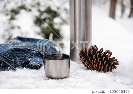 Pair of traditional felt winter boots standing next to snow shovel in snowy garden. Outdoor winter work and rural lifestyle scene. Pair of traditional felt winter boots standing next to snow shovel in snowy garden. Outdoor winter work and rural lifestyle scene. 135046399