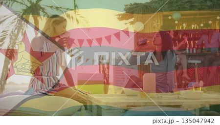 Sipping bottled drinks blonde and brunette women sitting at beachside tiki bar, with pallet table Sipping bottled drinks blonde and brunette women sitting at beachside tiki bar, with pallet table 135047942