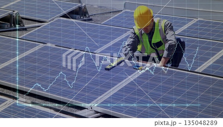 Inspecting helmeted technician leveling panels on rooftop with spirit level, copy space 135048289