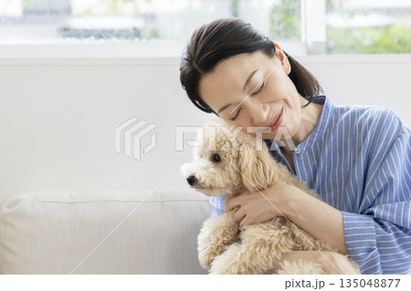 愛犬を抱く50代の女性 135048877