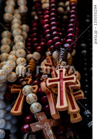 Different Christian crosses made of metal and wood hang for sale in a church store, symbolising faith, spirituality, religion, tradition, and sacred items. Religious symbol 135050294