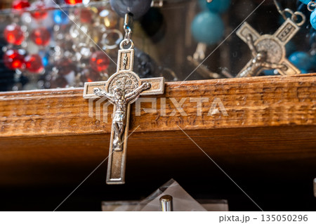 Different Christian crosses made of metal and wood hang for sale in a church store, symbolising faith, spirituality, religion, tradition, and sacred items. Religious symbol Different Christian crosses made of metal and wood hang for sale in a church store, symbolising faith, spirituality, religion, tradition, and sacred items. Religious symbol 135050296