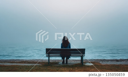 Woman alone on bench by water Woman alone on bench by water 135050859