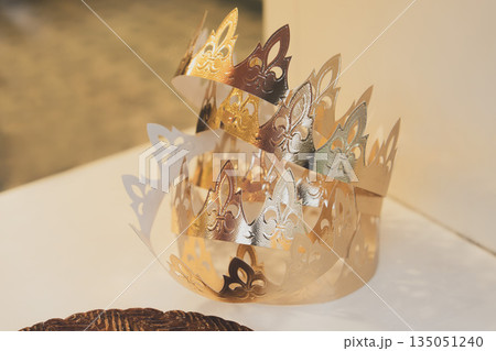 Golden crowns and French galette des rois in a bakery window on the French feast of Saint Epiphany Golden crowns and French galette des rois in a bakery window on the French feast of Saint Epiphany 135051240