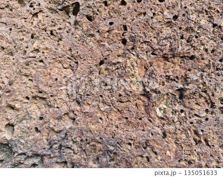 Detailed rough brown laterite stone texture surface with natural porous holes creating rugged weathered abstract background pattern for sturdy geological design 135051633