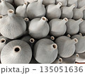 Large group of unglazed ceramic vase objects displayed in orderly pattern showing artistic texture and traditional craft design creating satisfying feeling of repetition and handmade beauty 135051636
