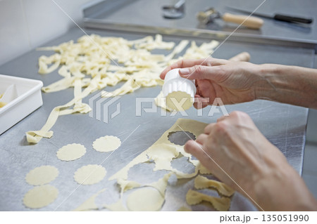 A woman cooks pasta. Close-up of the pasta cooking process. A mold for cutting out dough. Homemade pasta. Handmade work. A natural product. 135051990