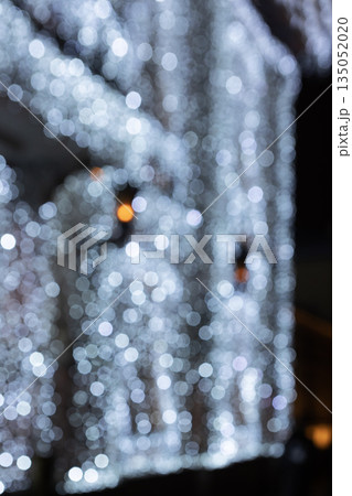 Festive garlands with burning light bulbs on the front of the building. Festive decoration. The concept of holidays. Out of focus. Bokeh. New Year's decor. 135052020