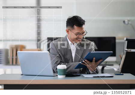 Mature businessman calculate and analyzing graph document financial with report and laptop in office. Mature businessman calculate and analyzing graph document financial with report and laptop in office. 135052071