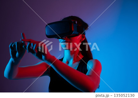 Female user wearing VR headset performing swipe gesture to navigate virtual interface 135052130