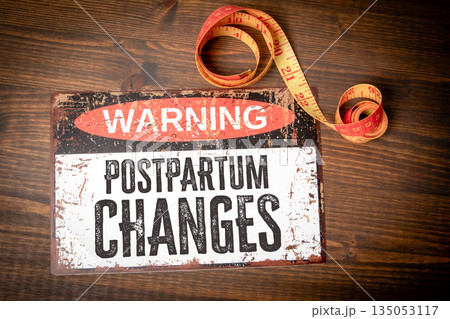 Warning Postpartum Changes Concept. Rustic Wooden Background With Measuring Tape Warning Postpartum Changes Concept. Rustic Wooden Background With Measuring Tape 135053117