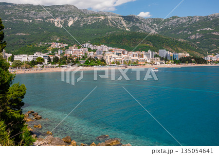 Coastal city panorama with mountains and waterfront shoreline, Montenegro. Urban development, natural landscape integration, and seaside lifestyle shaping balanced coastal living. 135054641