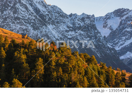 small cabin is perched on a hillside, surrounded by high mountains 135054731