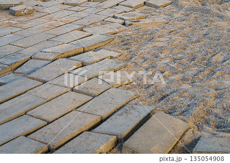 A picture of the street paving slabs, which had partially become unusable and was dismantled for the future re-laying process along with fine gravel as a cushion for the main support. 135054908