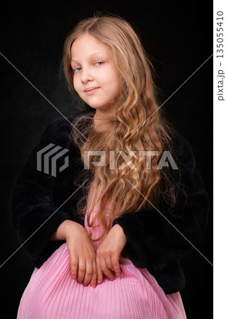 Portrait of a little girl with long white hair on a dark background. 135055410