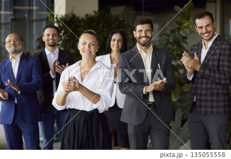 Happy applause of female business leader and office team standing together 135055558