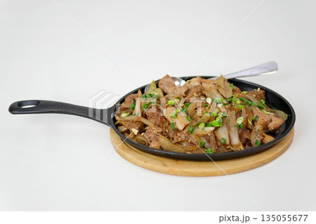 A stir fried beef with onion and green pepper sizzling on hot skillet, savory and aromatic A stir fried beef with onion and green pepper sizzling on hot skillet, savory and aromatic 135055677