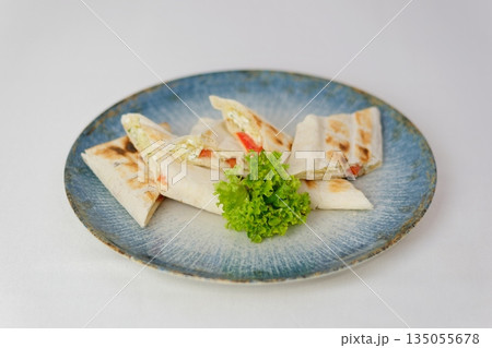 Mexican quesadillas with chicken, green beans salad and salsa on a white plate Mexican quesadillas with chicken, green beans salad and salsa on a white plate 135055678
