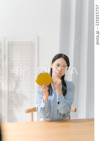 お財布を持って悲しい表情をする女性 135055737
