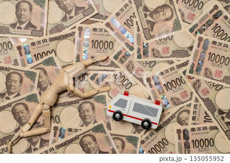 倒れた人形と救急車と敷き詰められた一万円札 135055952