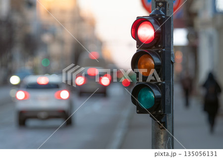 Traffic light shows red signal on urban street with cars 135056131