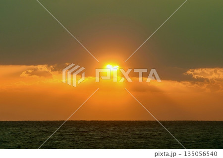 雲から顔を出した夕日がハートマーク 135056540