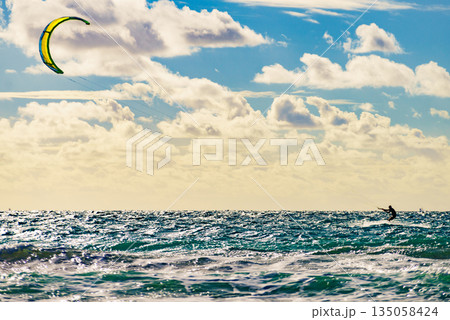 Kite surfer riding waves. Kiteboarding sport. 135058424