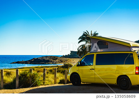 Camper van with tent on roof on beach 135058609