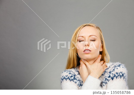 Woman having sore throat feeling pain 135058786