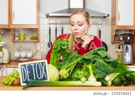 Woman having green diet vegetables, detox sign 135058821