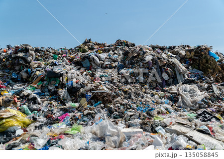 Littered landscape displays heaps of garbage and plastic under a bright blue sky, emphasizing the urgent need for better waste management solutions Littered landscape displays heaps of garbage and plastic under a bright blue sky, emphasizing the urgent need for better waste management solutions 135058845