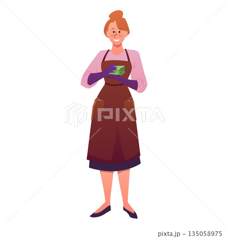 A woman in gloves and an apron holds a bar of natural green soap. 135058975