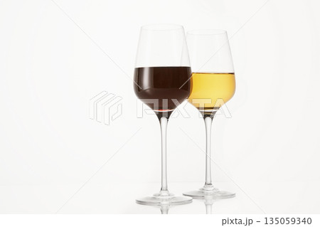 Two wineglasses half filled with red and white wine. 135059340
