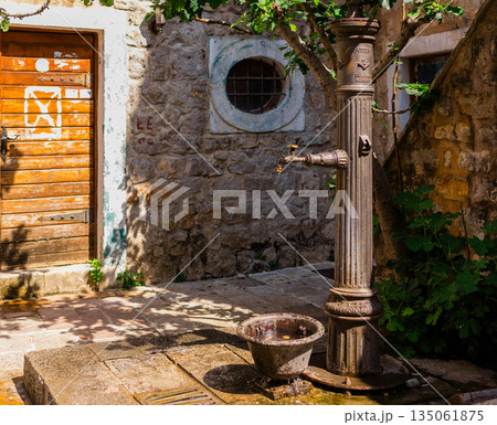Vintage street fountain with flowing water. Urban heritage, public utility, and Mediterranean charm. Vintage street fountain with flowing water. Urban heritage, public utility, and Mediterranean charm. 135061875