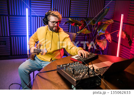 Sound engineer working at mixing panel in the boutique recording studio. 135062633