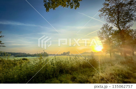 A Beautiful Sunrise Over a Vast and Serene Landscape Awaits You and Inspires Tranquility A Beautiful Sunrise Over a Vast and Serene Landscape Awaits You and Inspires Tranquility 135062757
