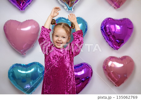 A laughing little girl waves her hands greeting and congratulating on Valentine's Day A laughing little girl waves her hands greeting and congratulating on Valentine's Day 135062769