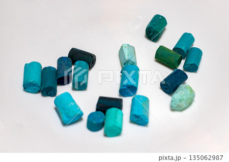 Dry pastel on a white background. Pieces of broken teal dry pastel, art supplies for painting and drawing. 135062987
