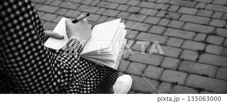 Girl holds a book to write Girl holds a book to write 135063000