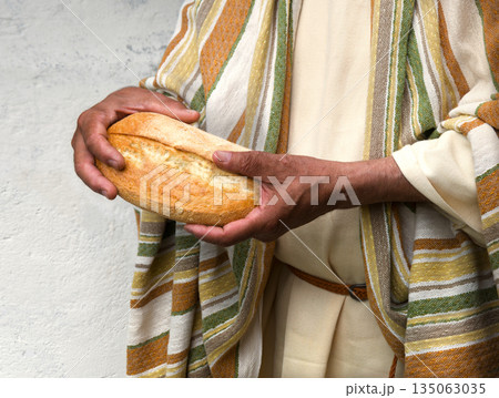 Man's hans holding fresh bread Man's hans holding fresh bread 135063035