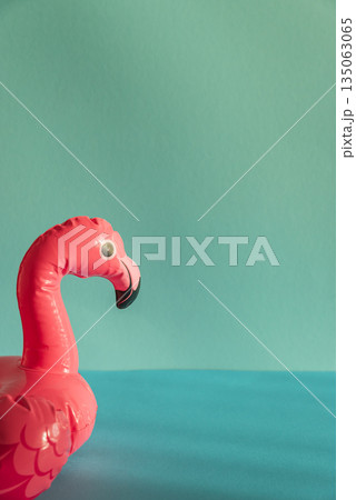 Pink Flamingo Shaped Pool Float on Turquoise Water under Sunlight. Front view Pink Flamingo Shaped Pool Float on Turquoise Water under Sunlight. Front view 135063065