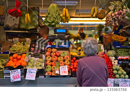 Old lady standing at a fruit stand at the market of Cadiz Old lady standing at a fruit stand at the market of Cadiz 135063788