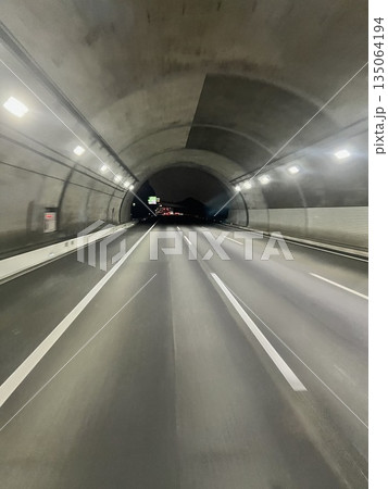 トンネル出口へ向かって走行する高速道路の奥行きある風景 トンネル出口へ向かって走行する高速道路の奥行きある風景 135064194