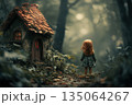 Little girl stands before a small whimsical house in an enchanting forest at dusk 135064267