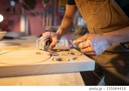 Woodworker using caliper to check upcoming lamp components, prepared patterns for bespoke furniture Woodworker using caliper to check upcoming lamp components, prepared patterns for bespoke furniture 135064418