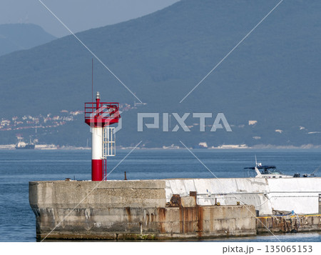 Lighthouse at the entrance to the port of Novorossiysk, Russia, standing on a concrete pier Lighthouse at the entrance to the port of Novorossiysk, Russia, standing on a concrete pier 135065153