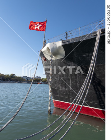 Mooring rope tied to a pier on the shore. Ship rope fastened to the dock in a mushroom shape 135065200