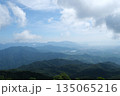 A breathtaking view of a majestic mountain range, with a few scattered clouds in the sky 135065216