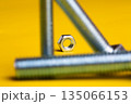 Metal Screw and Bolt Isolated on Vibrant Yellow Background: Construction and Engineering Essentials 135066153