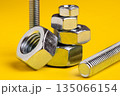 Metal Screw and Bolt Isolated on Vibrant Yellow Background: Construction and Engineering Essentials 135066154